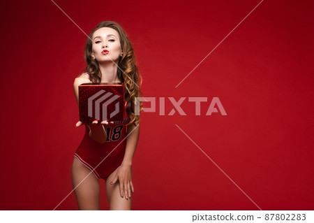 A beautiful woman in a red swimsuit with bright A beautiful woman in a red swimsuit with bright 87802283