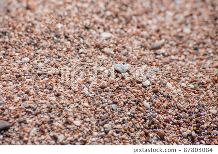 Small sea pebbles with stones with a reddish tint 87803084