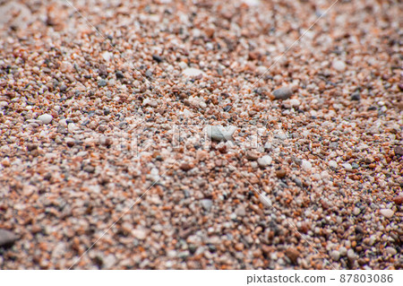 Small sea pebbles with stones with a reddish tint 87803086