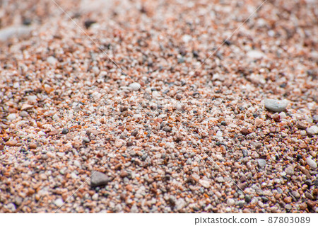 Small sea pebbles with stones with a reddish tint 87803089