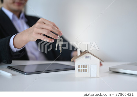 Cropped shot of businessman holding house model and keys. Real estate investment and insurance concept. Cropped shot of businessman holding house model and keys. Real estate investment and insurance concept. 87805421