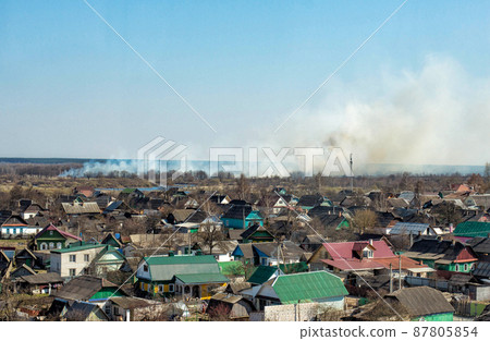 Thick pillar of smoke against a blue sky from forest fires and burning dry grass, copy space 87805854