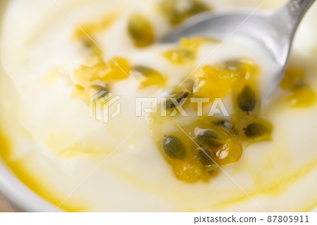 Yogurt with passion fruit juice in bowl with spoon, Healthy eating, Close up 87805911