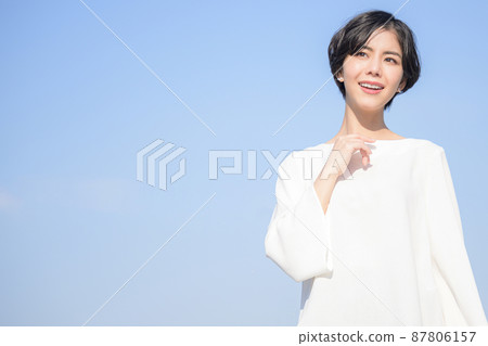 一個美麗的女人盯著上面有藍天背景 一個美麗的女人盯著上面有藍天背景 87806157