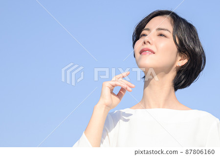 一個美麗的女人盯著上面有藍天背景 一個美麗的女人盯著上面有藍天背景 87806160