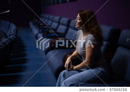 Caucasian red haired woman sits on the last row Stock Photo