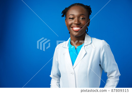 Portrait of young african female doctor in blue studio 87809315