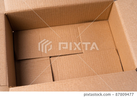 Cardboard box on beige background in studio 87809477