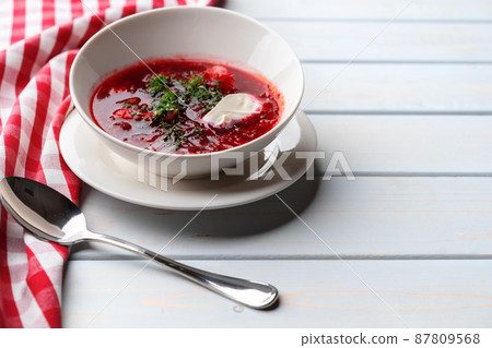 Bowl of beet root soup borsch on white wooden background Bowl of beet root soup borsch on white wooden background 87809568