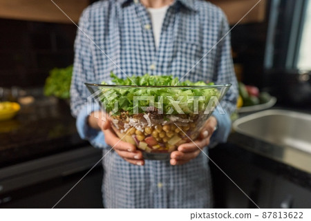 Bowl of fresh green salad in the women's hand. 87813622