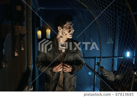 Spooky zombie man in business suit walking 87813685