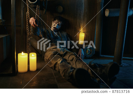 Chained zombie in basement of abandoned house 87813716
