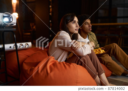 Family couple watching scary movie on projector 87814002