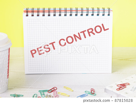 Pest Control text on a notebook standing on a table on a yellow background Pest Control text on a notebook standing on a table on a yellow background 87815028