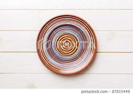 Top view of empty colorful plate on wooden background. Empty space for your design Top view of empty colorful plate on wooden background. Empty space for your design 87815449