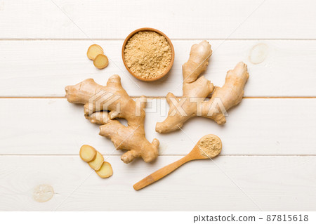 Finely dry Ginger powder in bowl with green leaves isolated on colored background. top view flat lay 87815618
