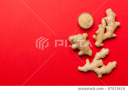 Finely dry Ginger powder in bowl with green leaves isolated on colored background. top view flat lay 87815619