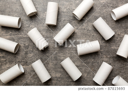 Empty toilet paper roll on colored background. Recyclable paper tube with metal plug end made of kraft paper or cardboard 87815693