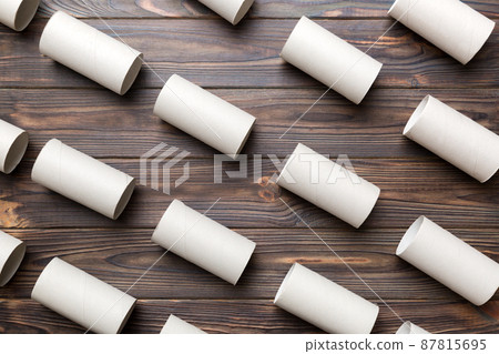 Empty toilet paper roll on colored background. Recyclable paper tube with metal plug end made of kraft paper or cardboard 87815695