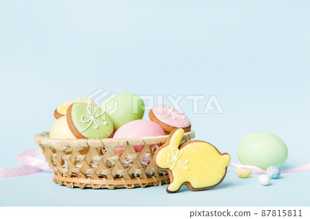 Colorful easter cookies in basket with Multi colors Easter eggs on colored background . Pastel color Easter eggs. holiday concept with copy space Colorful easter cookies in basket with Multi colors Easter eggs on colored background . Pastel color Easter eggs. holiday concept with copy space 87815811