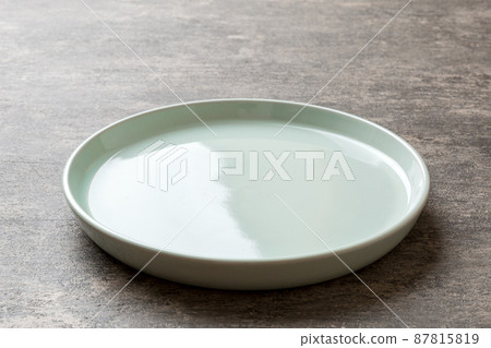 Perspective view of empty blue plate on cement background. Empty space for your design Perspective view of empty blue plate on cement background. Empty space for your design 87815819