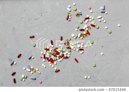 assorted pills and tablets top border over colored background. Many different pills and space for text on colorful background, top view 87815846