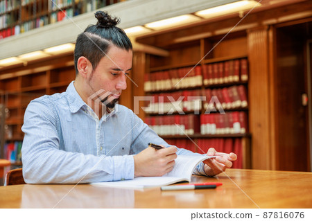 International students studying in a large library 87816076