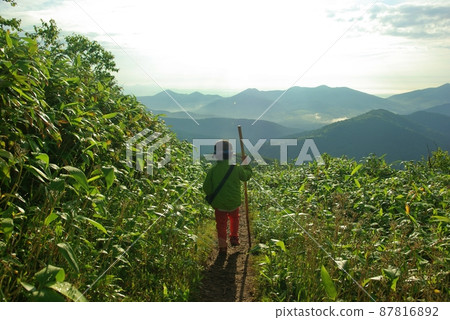A boy walking along a ridge 87816892
