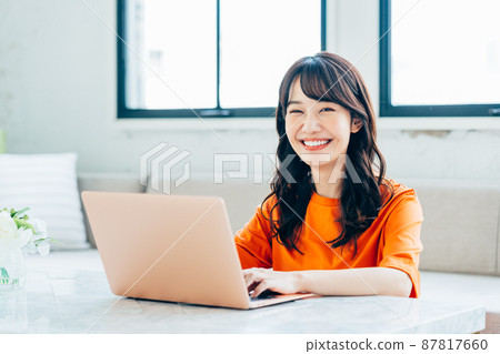 Young woman using a computer in the living room Young woman using a computer in the living room 87817660