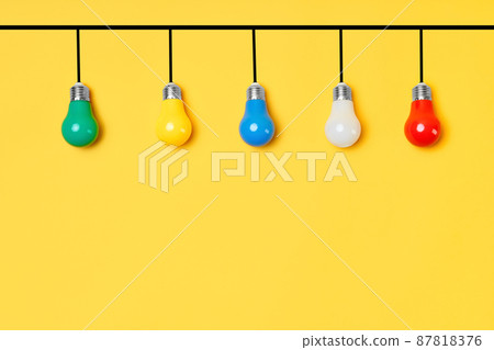 Creative layout with multicolored lightbulbs on yellow background Creative layout with multicolored lightbulbs on yellow background 87818376