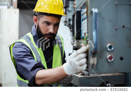 Engineering male workers wear yellow helmet working at operating machine. 87818882
