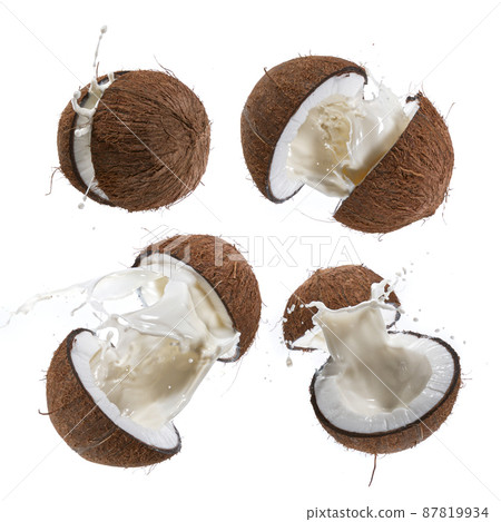 Cracked Coconut with milk splash flying in the air. 87819934
