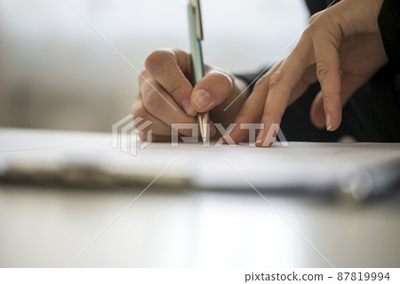 Hands of a person writing on a notepad Hands of a person writing on a notepad 87819994