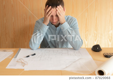Stess, overwork and tired young architect working on project at home office 87820068
