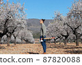 Young woodcutter in village with rural area around and flowering trees 87820088