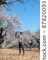 Young man gardener smelling flowers sorrounded by rural landscape 87820093
