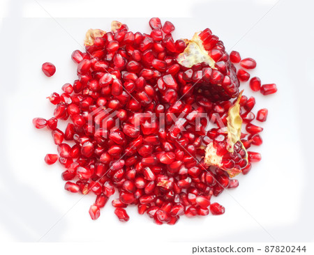 Red ripe pomegranate grains on white background. Red ripe pomegranate grains on white background. 87820244