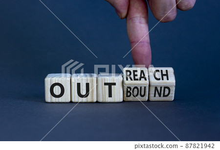 Outreach or outbound symbol. Businessman turns wooden cubes and changes the word 'outbound' to 'outreach'. Beautiful grey table grey background. Business, outreach or outbound concept. Copy space. 87821942