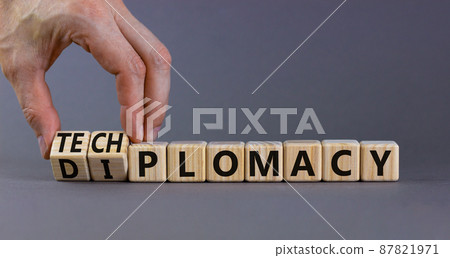Diplomacy or techplomacy symbol. Businessman turns cubes and changes the concept word diplomacy to techplomacy. Beautiful grey background, copy space. Business, diplomacy or techplomacy concept. Diplomacy or techplomacy symbol. Businessman turns cubes and changes the concept word diplomacy to techplomacy. Beautiful grey background, copy space. Business, diplomacy or techplomacy concept. 87821971