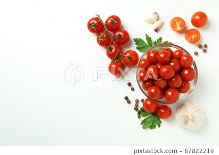 Bowl with pickled tomatoes and ingredients on white background Bowl with pickled tomatoes and ingredients on white background 87822219