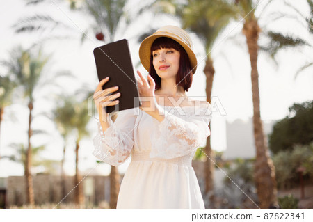 Cheerful business woman sitting using touch screen on tablet pc. Cheerful business woman sitting using touch screen on tablet pc. 87822341