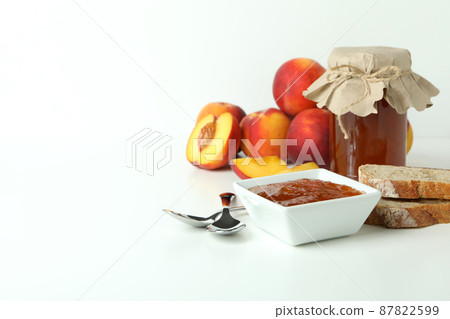 Peach jam and ingredients on white table 87822599