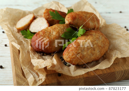 Concept of tasty food with cutlets on white wooden table Concept of tasty food with cutlets on white wooden table 87823177