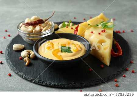 Tray with cheese sauce and ingredients on gray textured table Tray with cheese sauce and ingredients on gray textured table 87823239