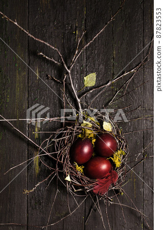 burgundy Easter eggs in a nest on wooden background burgundy Easter eggs in a nest on wooden background 87823553