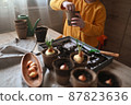 concept of gardening. little girl is engaged in planting seeds for seedlings, pouring earth into pots for growing crops. 87823636