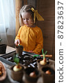 concept of gardening. little girl is engaged in planting seeds for seedlings, pouring earth into pots for growing crops. 87823637