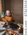 concept of gardening. little girl is engaged in planting seeds for seedlings, pouring earth into pots for growing crops. 87823638
