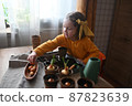 concept of gardening. little girl is engaged in planting seeds for seedlings, pouring earth into pots for growing crops. 87823639