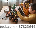 Happy children are planting plants at home. girl and boy sow seeds in natural gardening pots. 87823644